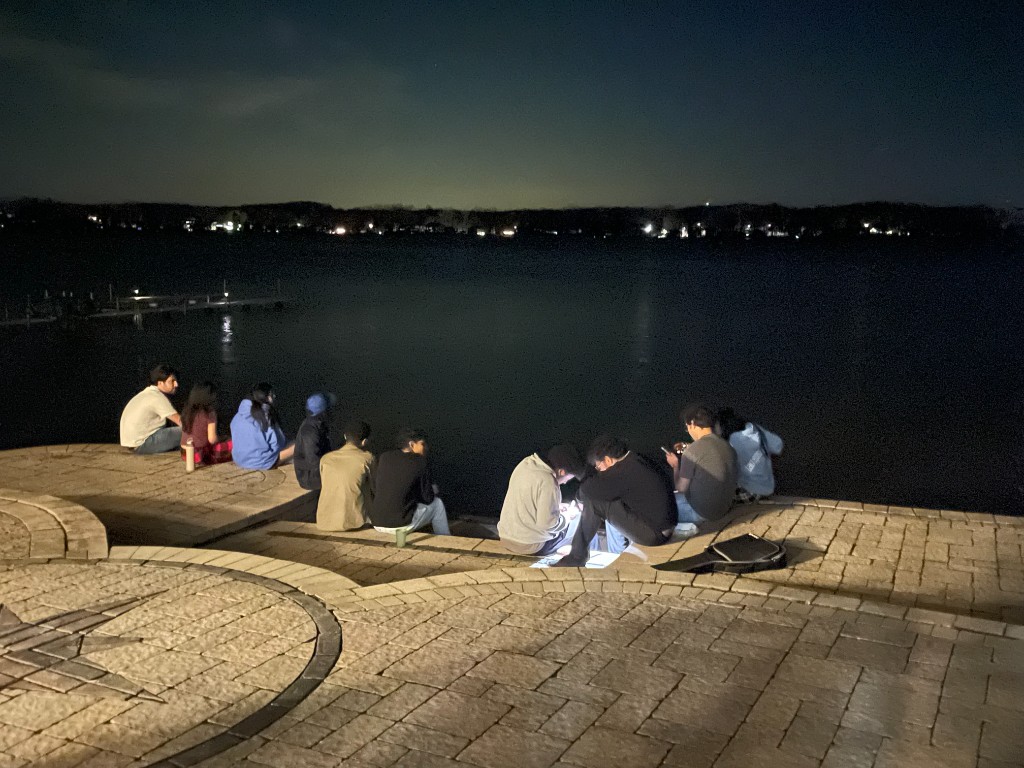 group of creators sitting by the water at night